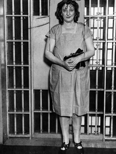 Walburga standing in front of jail cell