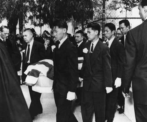 Pallbearers carry coffin