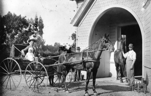 Man and baby in a horse drawn buggy