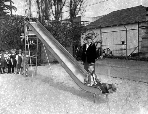 Kiddies have fun on slide in playground