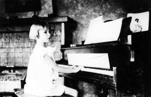 Child seated at piano