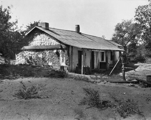 Adobe house with water pump