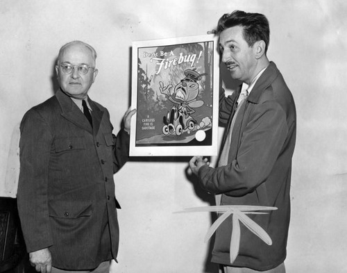 Walt Disney presenting a poster