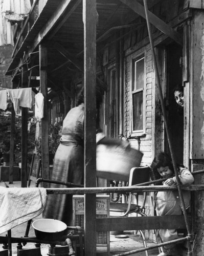 Washing clothes in a tub, slum dwelling