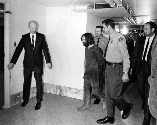 Handcuffed Charles Manson is led back to his cell