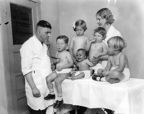 Doctor examines infants