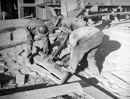 Oil workers assemble a pipe