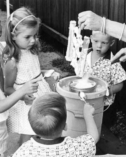 Ellen Donnelly, 5, helps Michaud children lick dasher