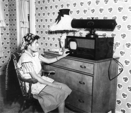 Woman adjusting television