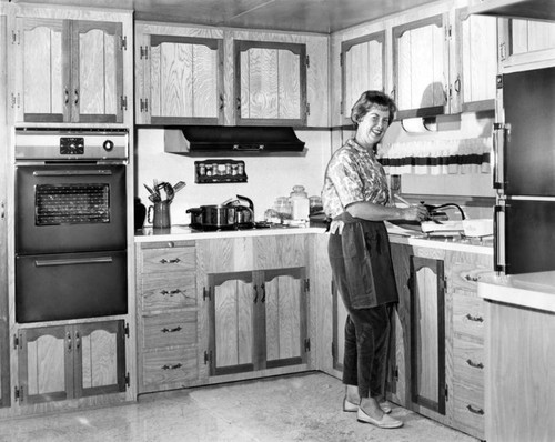 Mrs. Joseph Kelly prepares beef stroganoff in her mobile home in Pacoima park