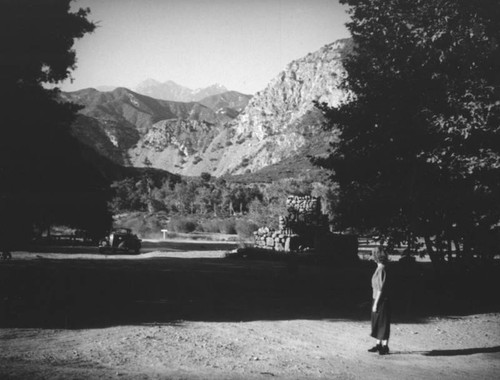 Ethel Schultheis in front of primitive stone structure at Camp Rincon