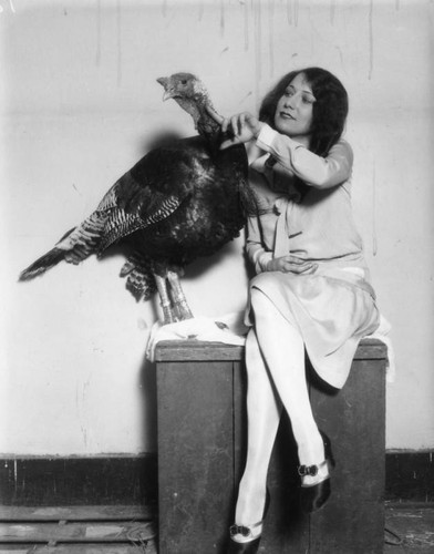 Woman petting a wild turkey
