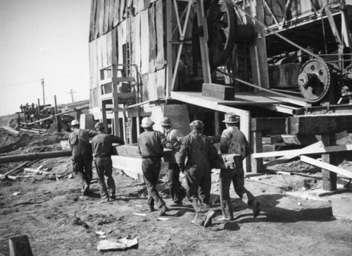 Carrying a beam in front of the drawworks, Montebello oil well