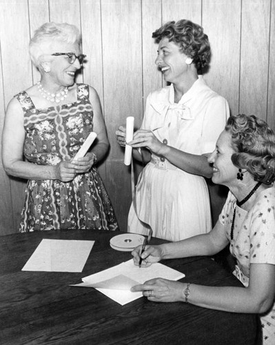 Auxiliary members ready merit certificates for luncheon