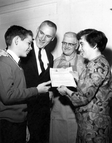 Mrs. Mary H. Krull hands her son, Ned, $2,000 prize