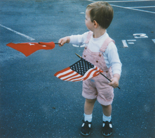 Little boy waves Turkish and American flags