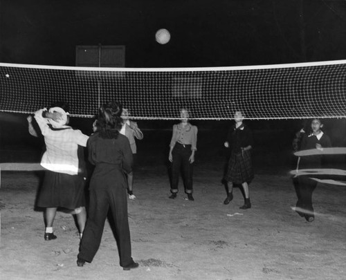 Girls playing volleyball at night