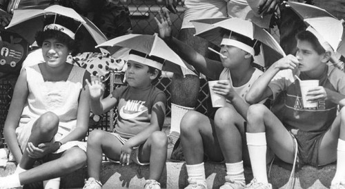 Parade watchers with umbrella hats