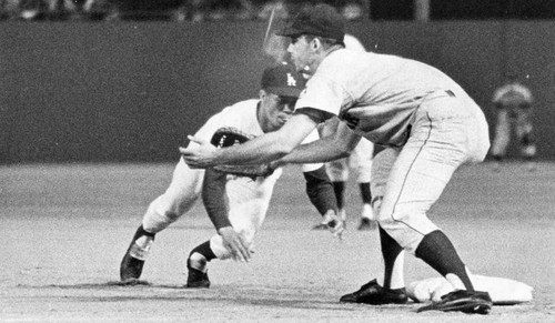 Dodger Maury Wills, who set an all-time base-stealing record last year, hustles back to first