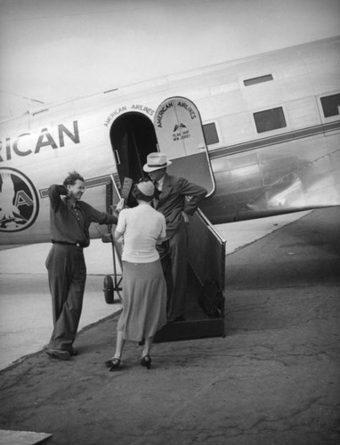 Passengers board an America Airlines plane