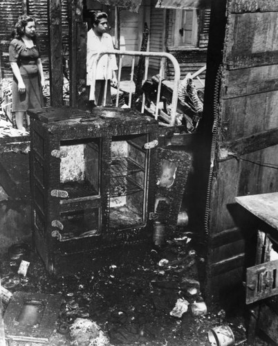 Poor family gazes at burned out home