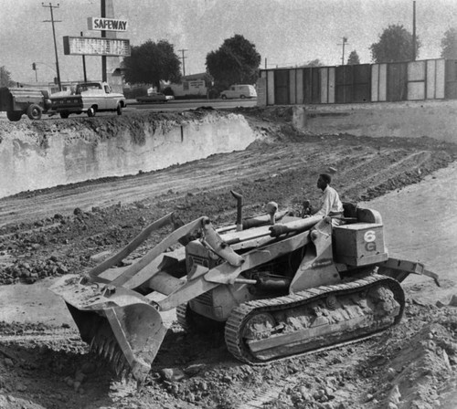 Bulldozer levels off excavation, Watts