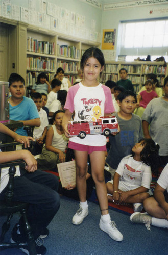 Young girl holding a toy fire truck, Cypress Park