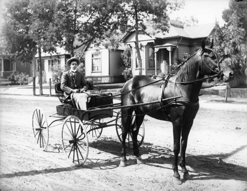 Man in cart in front of houses