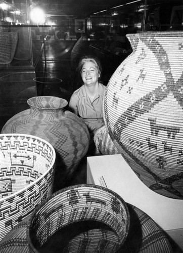 Southwest Museum assistant with baskets