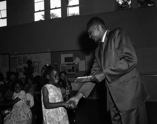 Councilman Tom Bradley presents reading award to students