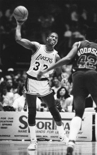 Magic Johnson about to make a pass down-court