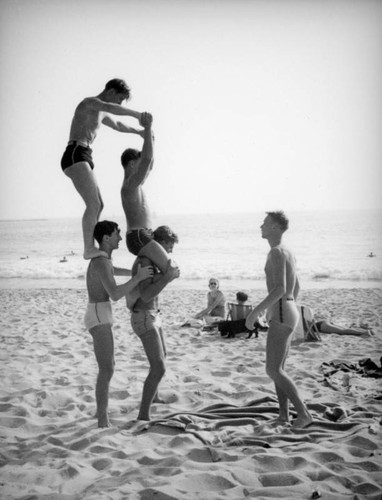 Attempting a human pyramid on the beach