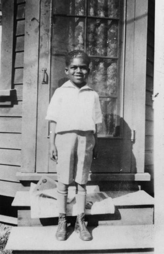 Boy in front of house