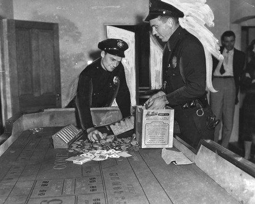 Officers examine dice table, chips and cards