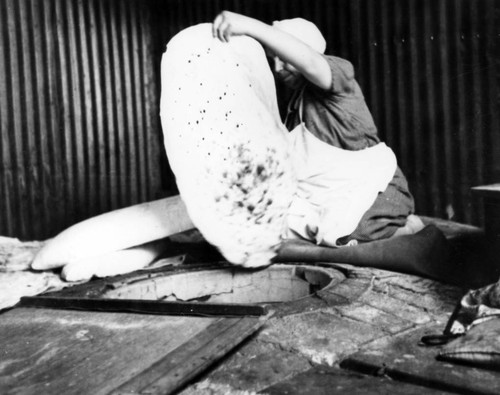 Woman in her kitchen kneads bread dough