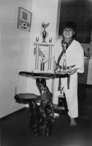 Mexican American boy with trophies