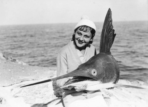 Woman holds swordfish