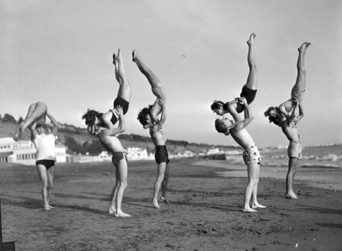 Group of acrobats on the beach, view 1