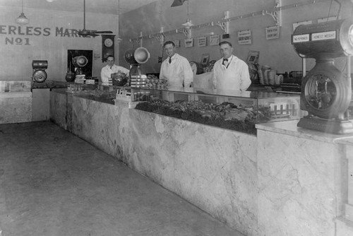 Butchers behind meat counter