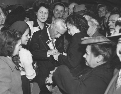 Charlie Chaplin signs autographs