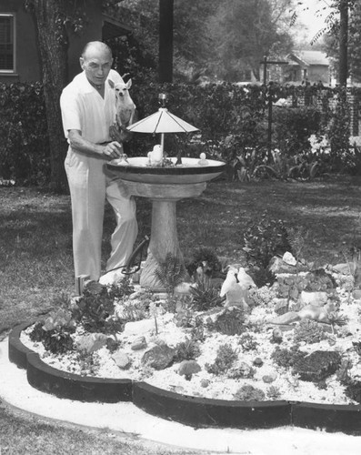 Voy Kay Apt alongside his cactus bed and bird bath