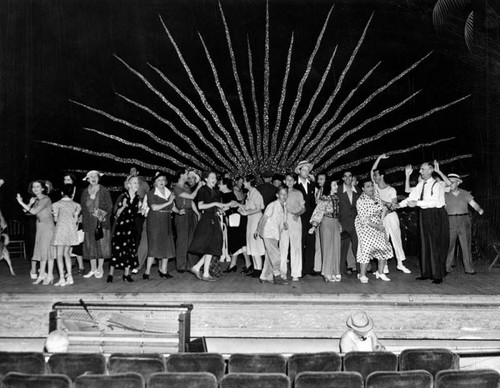 Cast members rehearse a finale on stage