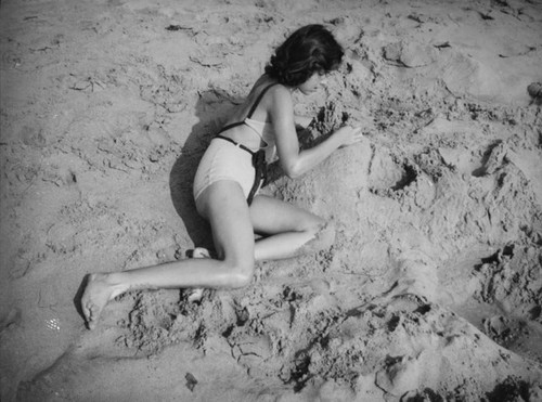 Young teen lying on the sand at the beach