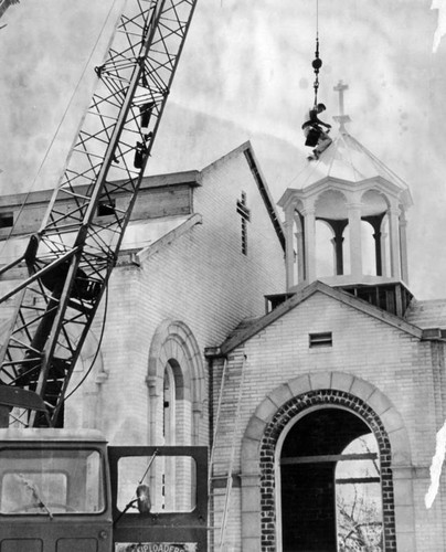 Crane lifts dome out of church and onto roof