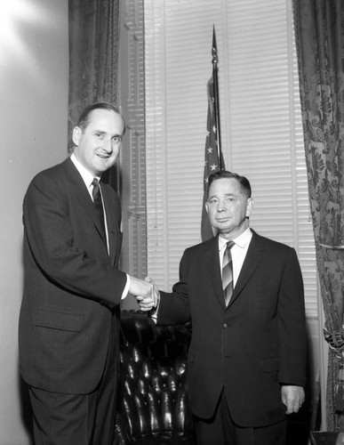 Representatives Rees and Albert shaking hands in Congressional Office in D.C