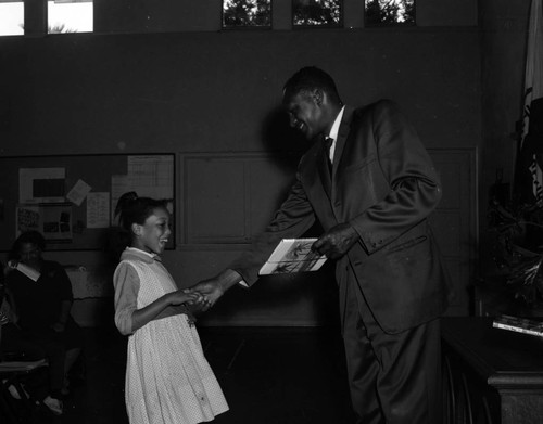 Councilman Tom Bradley presents reading award to students