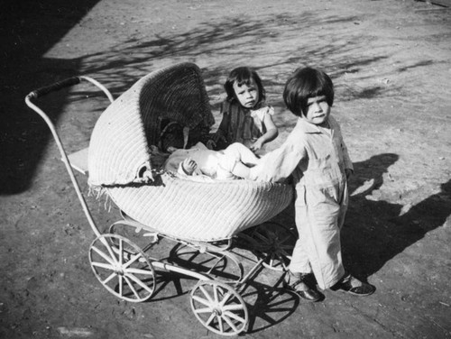 Children and baby carriage in the Santa Cruz Adobe courtyard