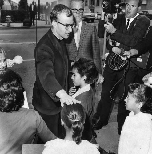 Rebel priest Father DuBay blesses kneeling picket