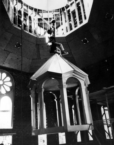 Crane lifts dome out of church and onto roof