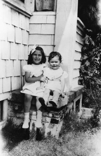 Two young girls dressed in white